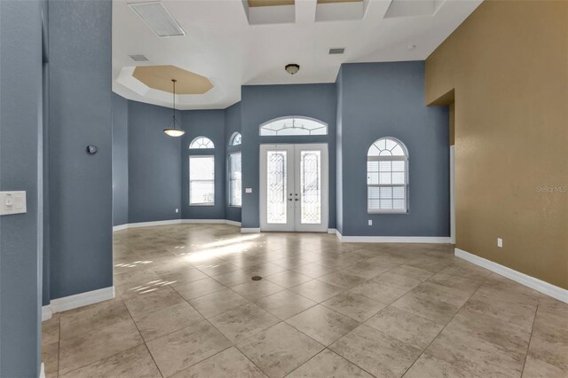 tiled foyer featuring french doors, baseboards, a high ceiling, and visible vents