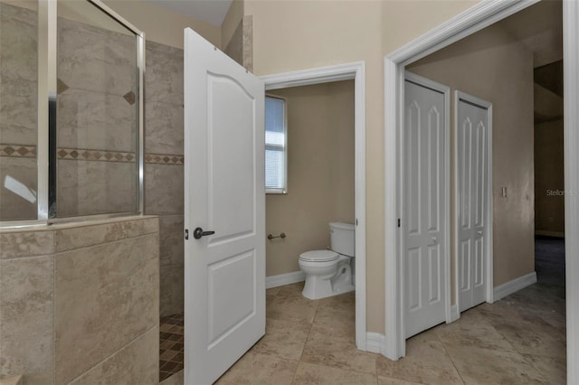 bathroom with tile patterned floors, baseboards, toilet, and walk in shower