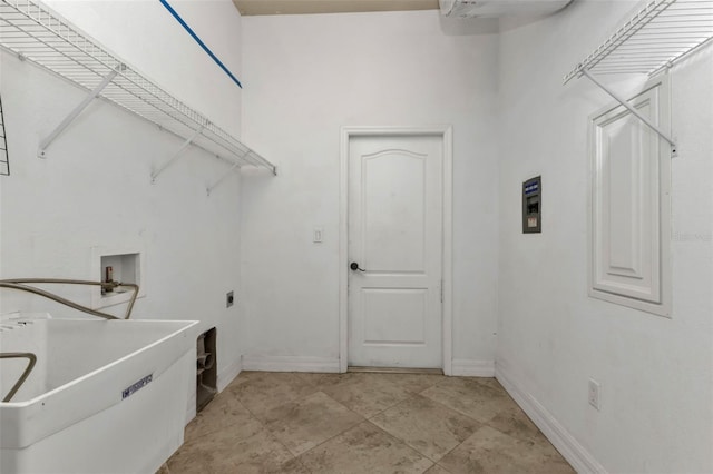 laundry room featuring laundry area, hookup for a washing machine, baseboards, and a sink