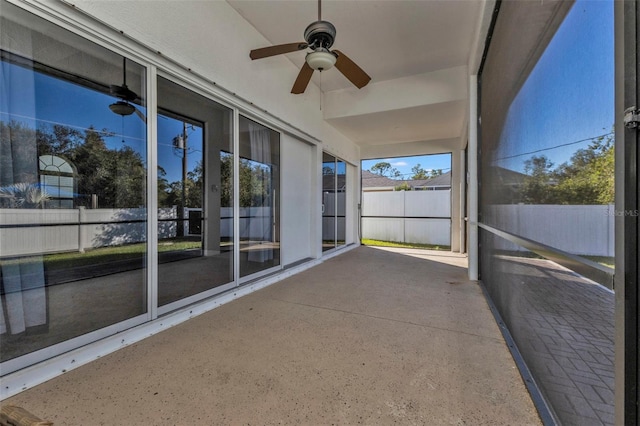 unfurnished sunroom featuring ceiling fan