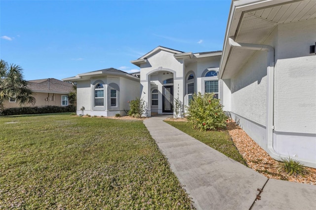 view of front of property featuring stucco siding and a front lawn