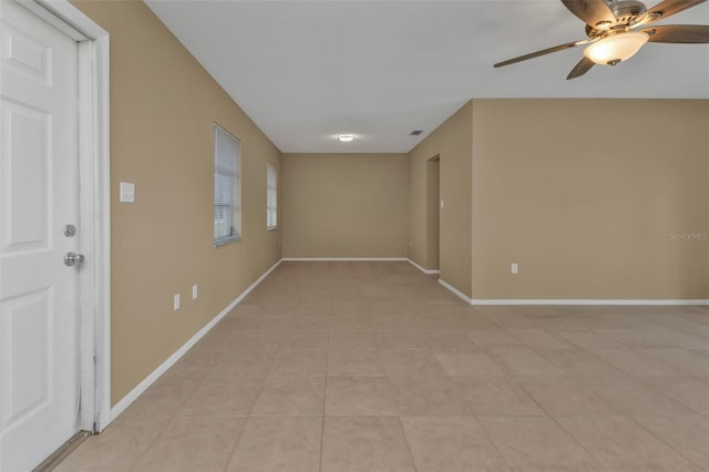 tiled spare room featuring ceiling fan