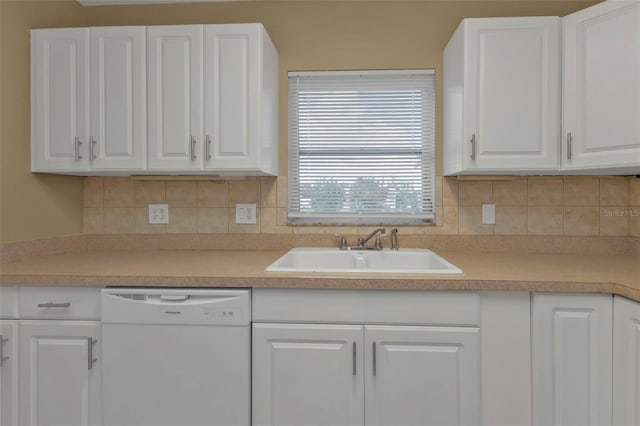 kitchen with tasteful backsplash, white cabinetry, sink, and white dishwasher