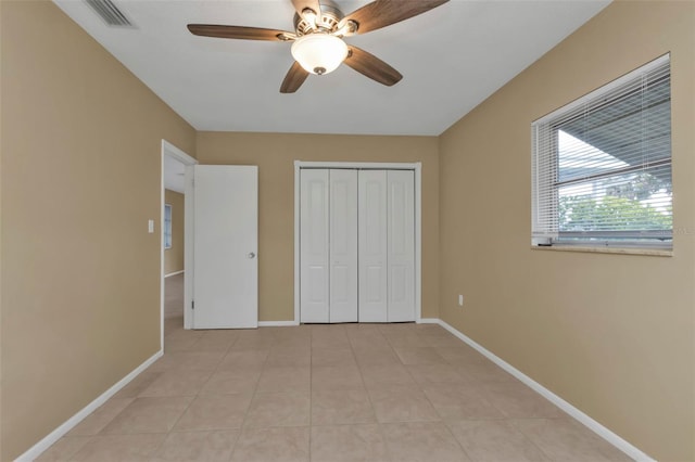 unfurnished bedroom with a closet, light tile patterned floors, and ceiling fan