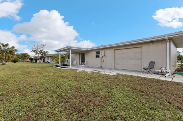 rear view of house with a patio area, a garage, and a yard