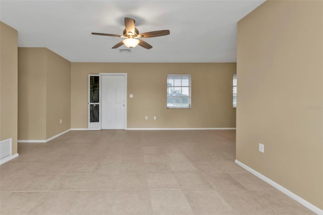 tiled spare room featuring ceiling fan