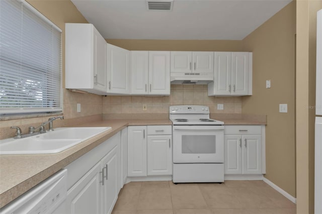 kitchen with backsplash, light tile patterned floors, sink, white cabinets, and white appliances