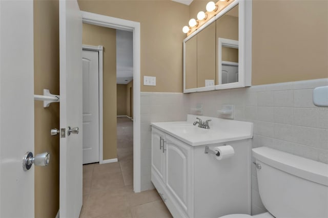 bathroom with vanity, tile patterned floors, toilet, and tile walls