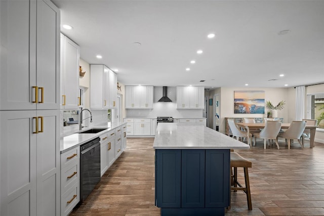 kitchen featuring a center island, white cabinets, black dishwasher, sink, and wall chimney range hood