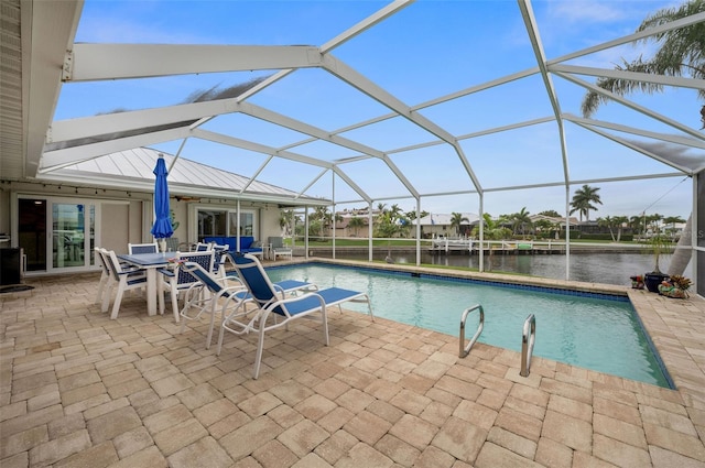 view of swimming pool featuring a patio area, a water view, and a lanai