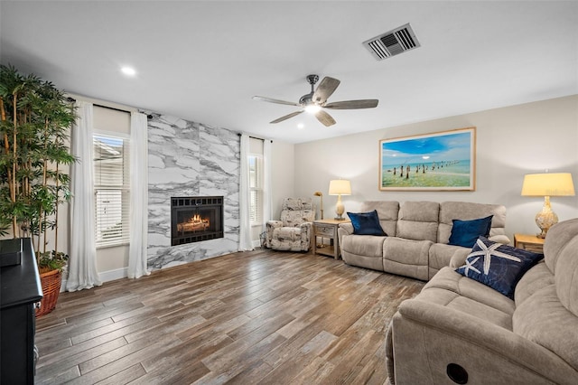 living room featuring ceiling fan, hardwood / wood-style floors, and a premium fireplace