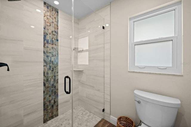 bathroom with toilet, wood-type flooring, and a shower with shower door