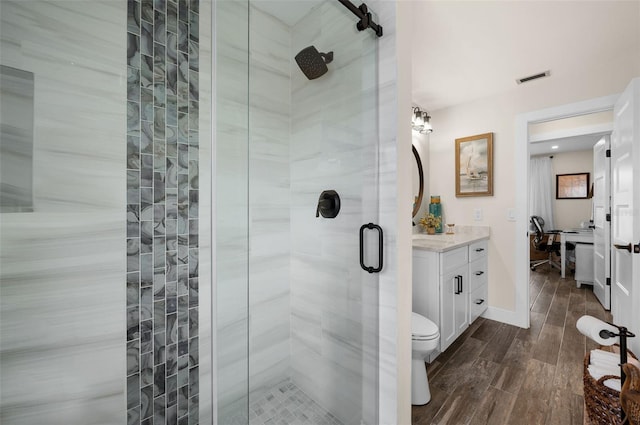 bathroom with toilet, an enclosed shower, vanity, and hardwood / wood-style flooring