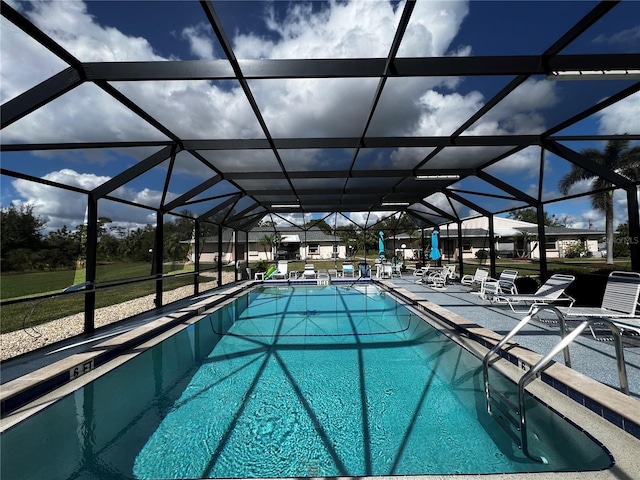 view of swimming pool with glass enclosure and a patio