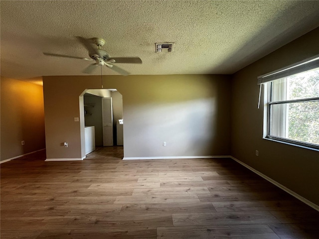 spare room with a textured ceiling, hardwood / wood-style flooring, and ceiling fan