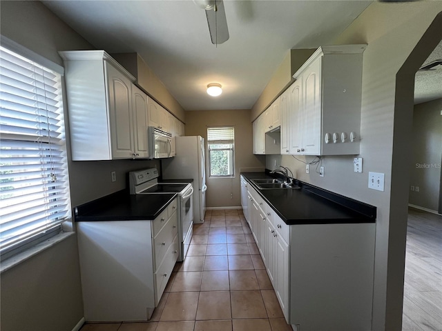 kitchen featuring light tile patterned floors, sink, white cabinets, white appliances, and ceiling fan