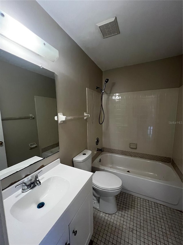 full bathroom with tile patterned flooring, vanity, tiled shower / bath combo, and toilet