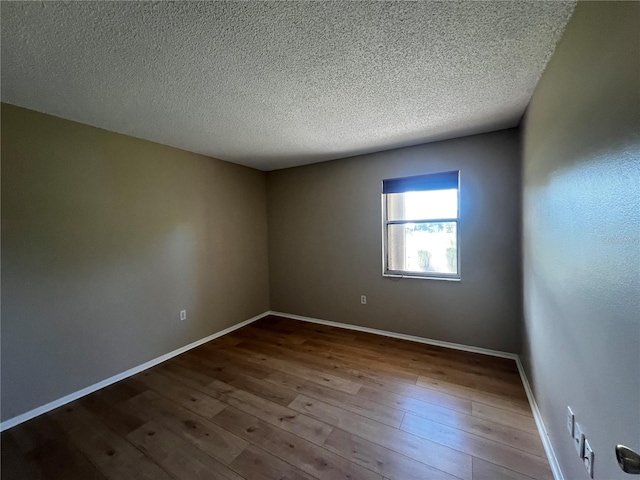 spare room with wood-type flooring and a textured ceiling