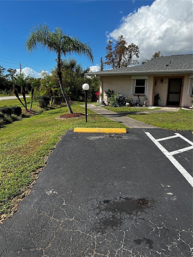 view of vehicle parking featuring a yard