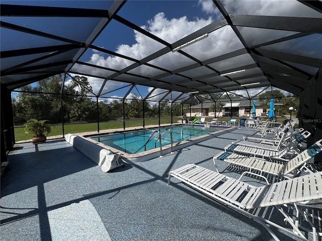 view of pool featuring glass enclosure and a patio area