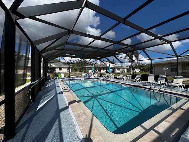 view of pool with glass enclosure and a patio area