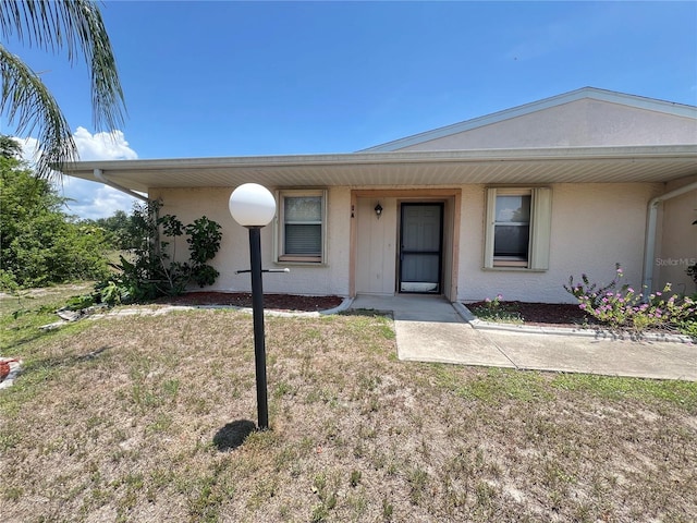 25068 Harborview Rd Unit 1A, Punta Gorda, FL 33980 - view of front facade featuring stucco siding and a front yard