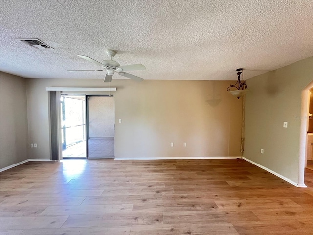 25068 Harborview Rd Unit 1A, Punta Gorda, FL 33980 - empty room with wood finished floors, a ceiling fan, a textured ceiling, and baseboards