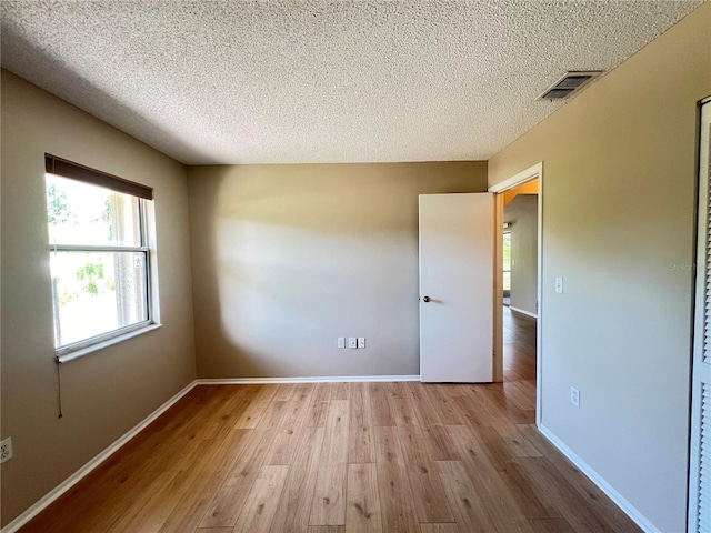 25068 Harborview Rd Unit 1A, Punta Gorda, FL 33980 - unfurnished room featuring wood finished floors, a textured ceiling, and baseboards