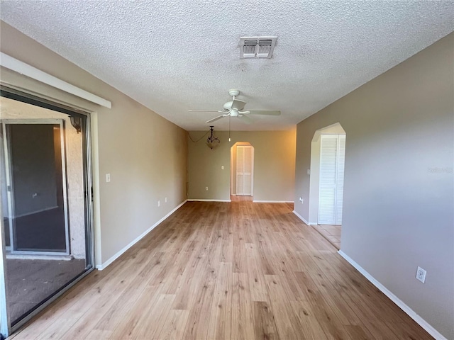 25068 Harborview Rd Unit 1A, Punta Gorda, FL 33980 - spare room with a ceiling fan, light wood-style floors, arched walkways, a textured ceiling, and baseboards