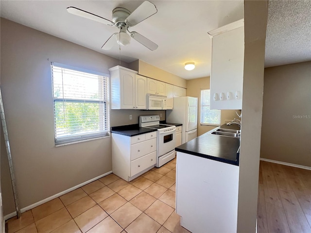 25068 Harborview Rd Unit 1A, Punta Gorda, FL 33980 - kitchen with white appliances, a sink, plenty of natural light, and white cabinets