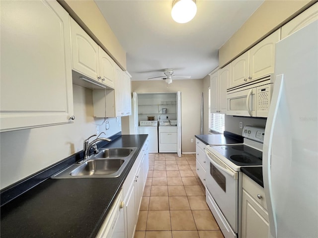 25068 Harborview Rd Unit 1A, Punta Gorda, FL 33980 - kitchen with white appliances, washing machine and clothes dryer, dark countertops, a sink, and white cabinets