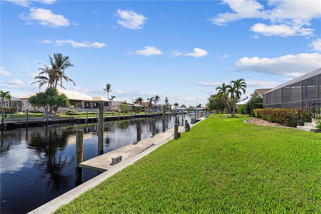 view of dock with a water view and a lawn