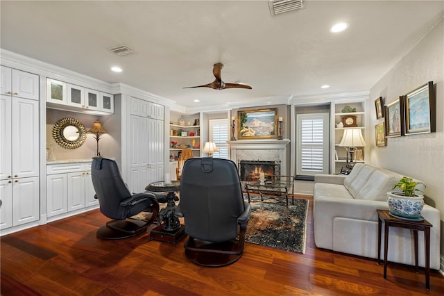 office with ceiling fan, dark hardwood / wood-style flooring, built in features, and crown molding