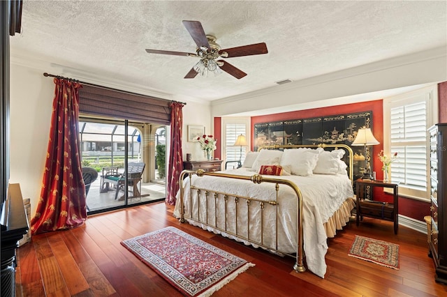 bedroom featuring ceiling fan, access to exterior, hardwood / wood-style floors, ornamental molding, and a textured ceiling