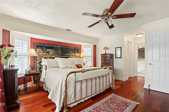 bedroom with ceiling fan, ornamental molding, dark hardwood / wood-style floors, and a textured ceiling