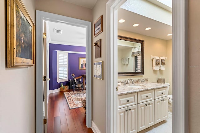 hallway featuring sink and light wood-type flooring