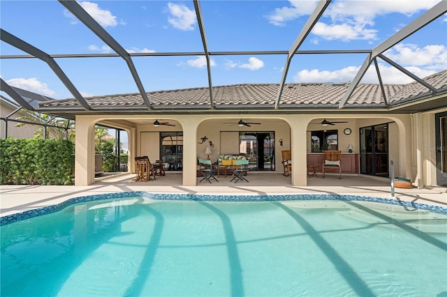 view of pool featuring ceiling fan, a patio area, and a lanai