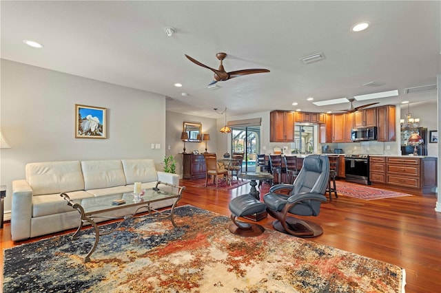 living room featuring dark wood-type flooring, ceiling fan, and sink