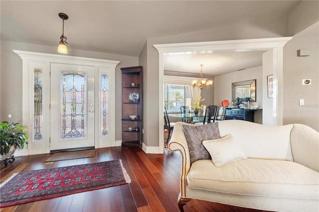 foyer entrance with dark hardwood / wood-style floors and an inviting chandelier