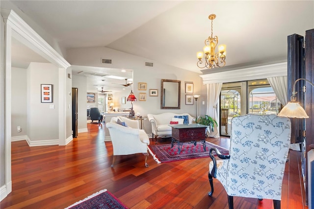 living room with hardwood / wood-style floors, vaulted ceiling, a wealth of natural light, and a notable chandelier