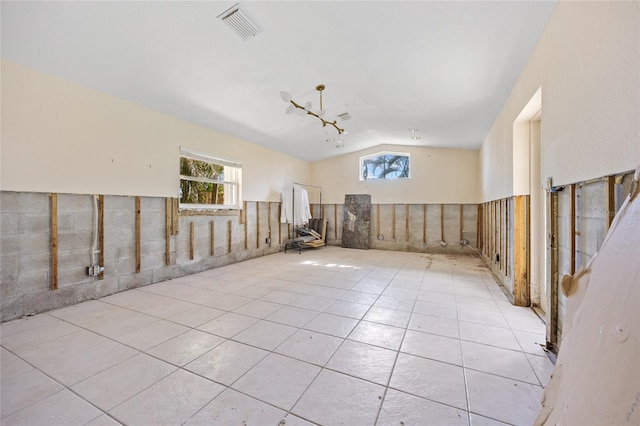 tiled empty room with tile walls and lofted ceiling