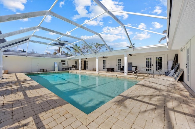 view of swimming pool with french doors, glass enclosure, and a patio