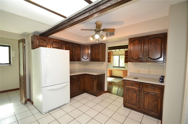 kitchen featuring tasteful backsplash, dark brown cabinets, beam ceiling, and white refrigerator