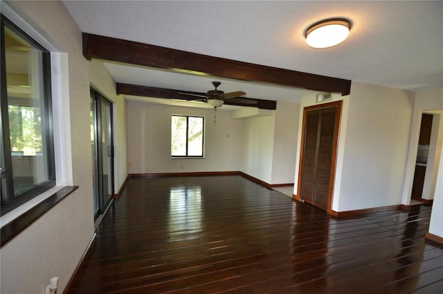 unfurnished room with beam ceiling, ceiling fan, a textured ceiling, and dark hardwood / wood-style floors