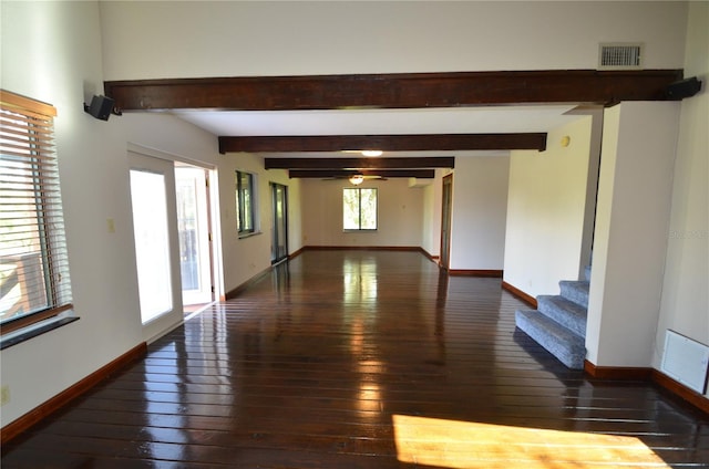 empty room with beam ceiling and dark hardwood / wood-style floors