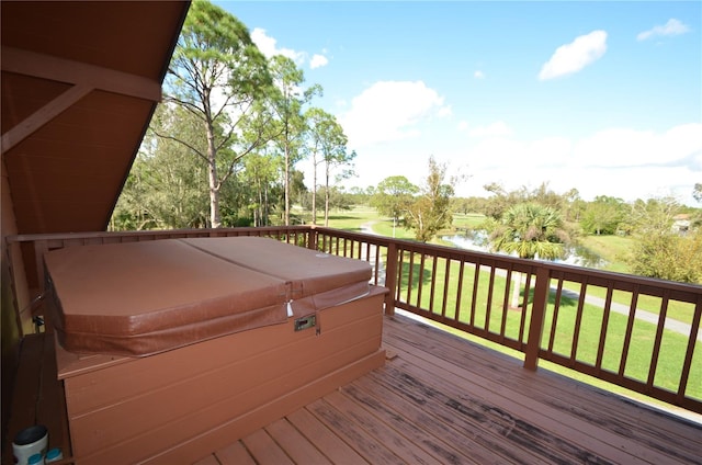 deck with a water view and a hot tub