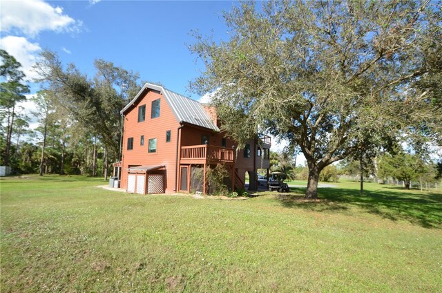 view of side of property with a yard and a wooden deck