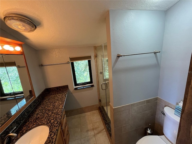 bathroom with tile patterned floors, toilet, a textured ceiling, and an enclosed shower