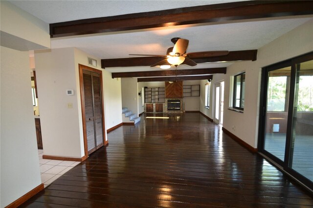 empty room with ceiling fan, beamed ceiling, and hardwood / wood-style flooring