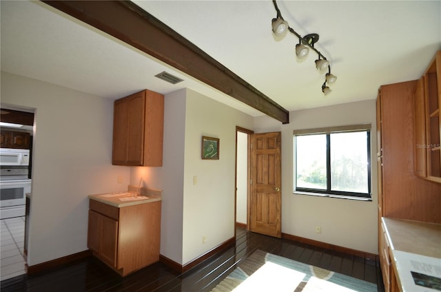 kitchen with beam ceiling, dark hardwood / wood-style flooring, and white appliances